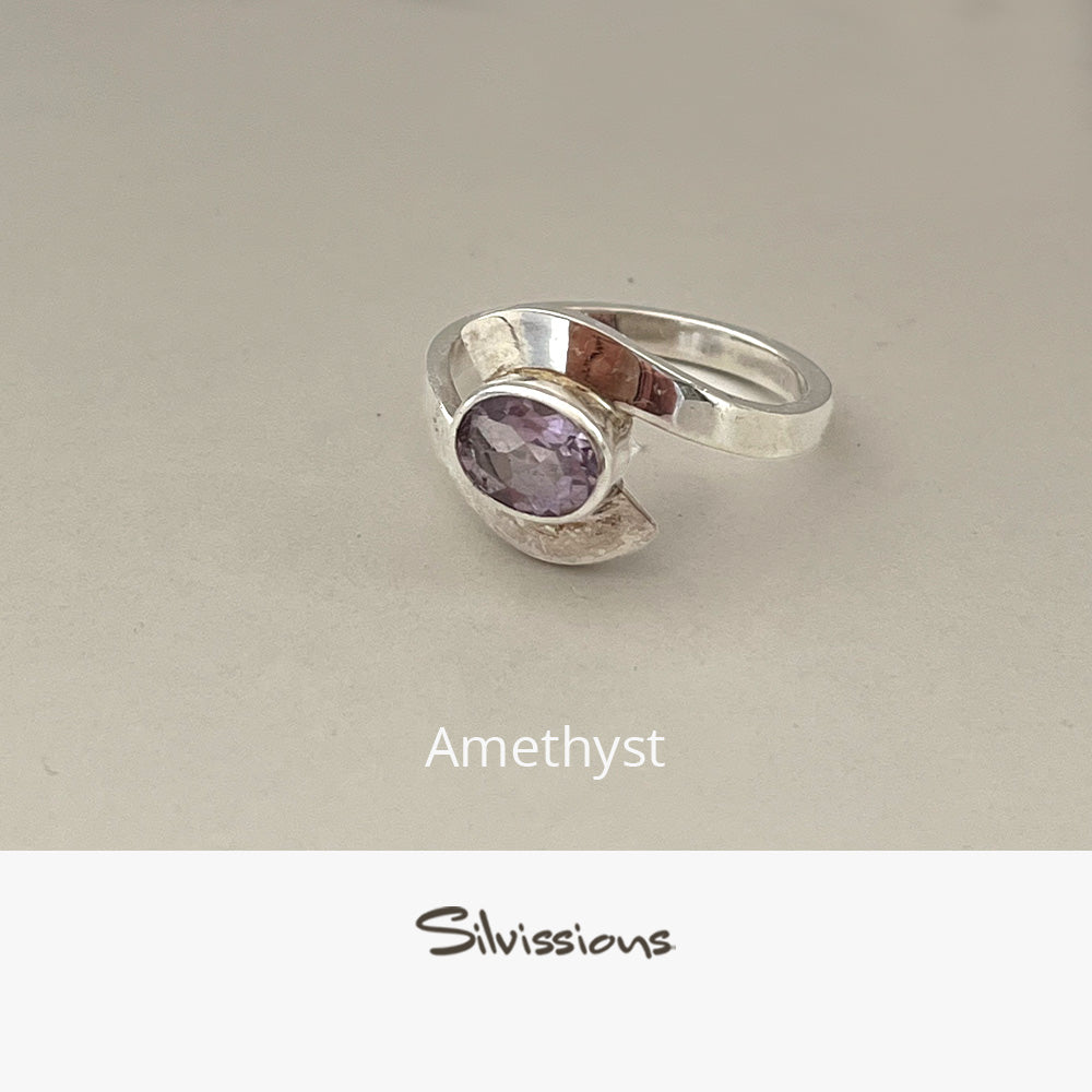 Silver ring with a purple gemstone on a beige background, branded 'Silvissions'.