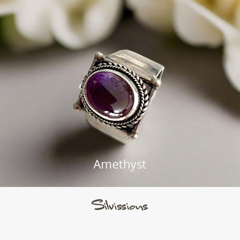 Silver ring with a purple gemstone on a light background, branded 'Silvissions'.