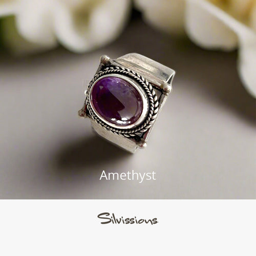 Silver ring with a purple gemstone on a light background, branded 'Silvissions'.