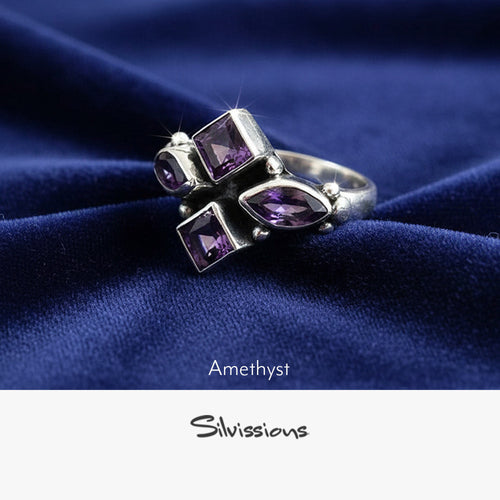 Silver ring with purple amethyst stones on a gray surface, featuring the brand 'Silvissions'.