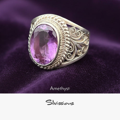 Silver ring with a pink amethyst stone on purple fabric, branded 'Silvissions'.