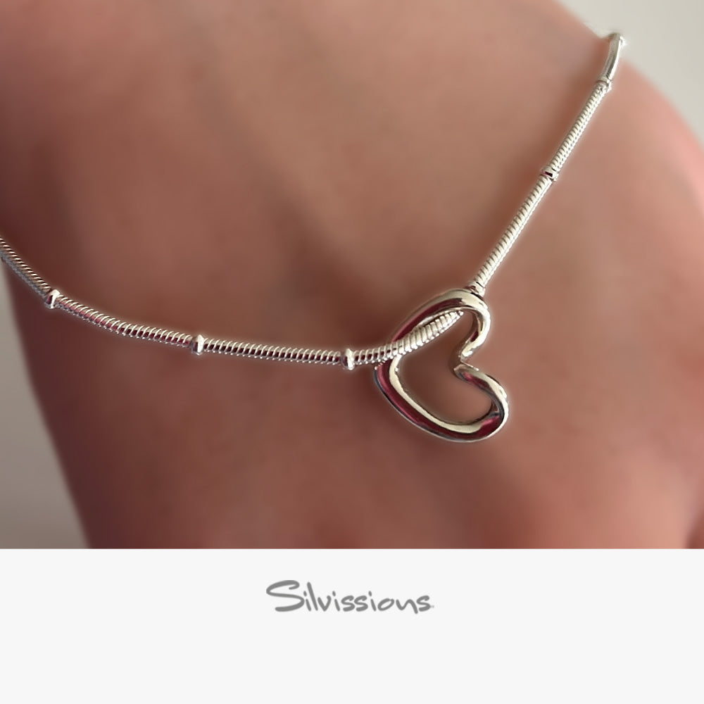 Silver ankle bracelet with a floating heart charm and 'Silvissions Jewelry' branding.