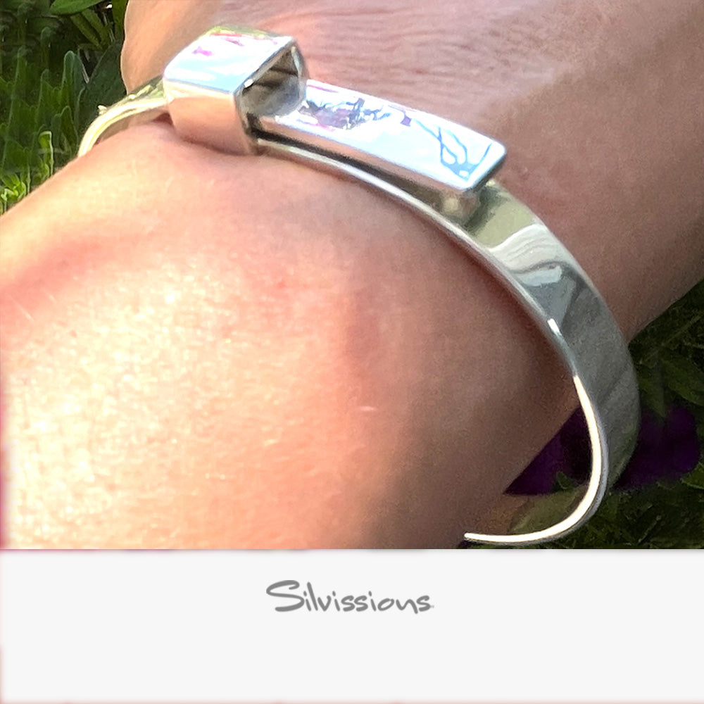 Silver bracelet on a wrist with 'Silvissions' branding, against a natural background.