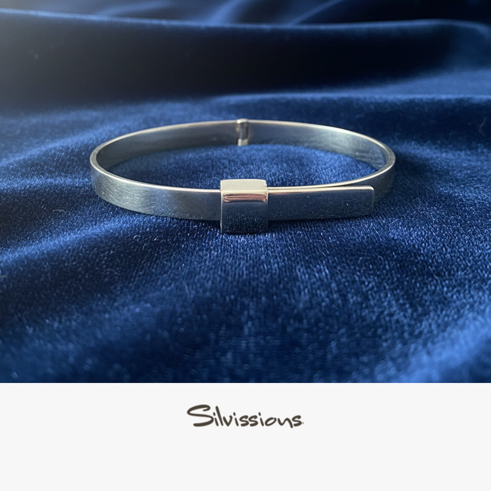Silver bracelet on a blue fabric background with 'Silvissions' branding.