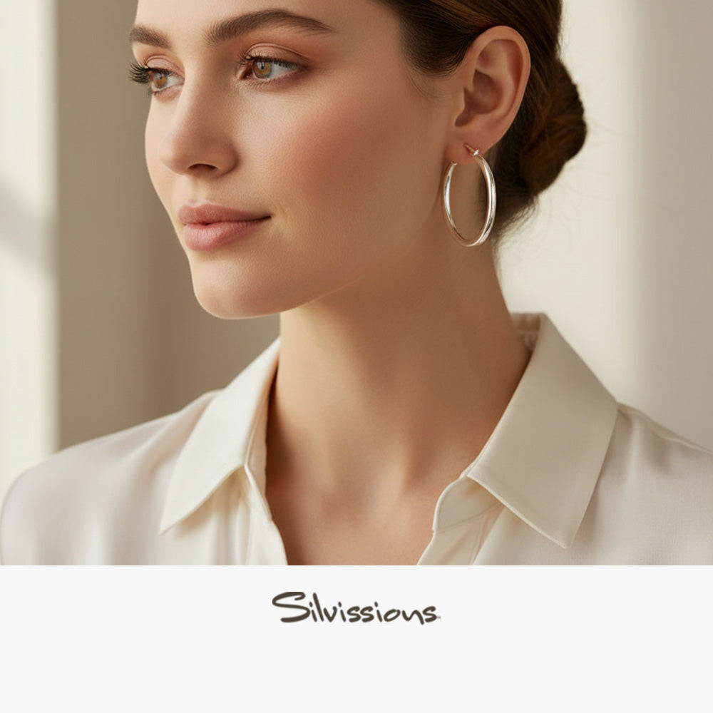 Woman wearing hoop earrings with a neutral background, featuring the brand 'Silvissions'.