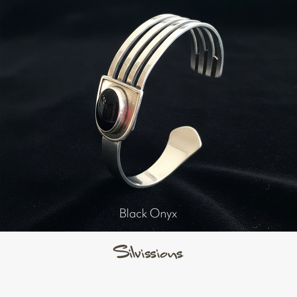 Silver bracelet with black onyx stone on a black background, branded 'Silvissions'.