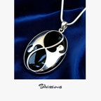 Black onyx pendant on a silver chain against a blue velvet background, with 'Silvissions' branding.