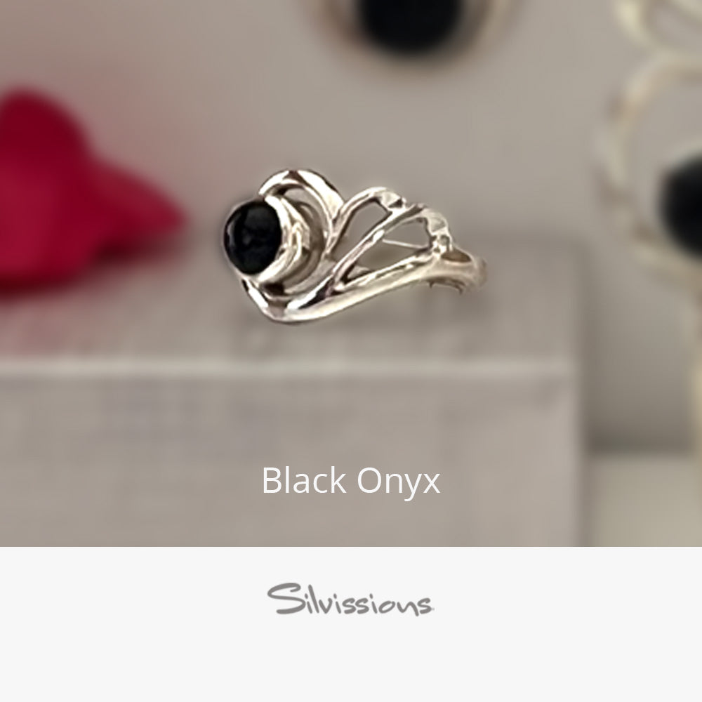 Silver ring with black onyx stone on a neutral background, featuring the brand 'Silvissions'.