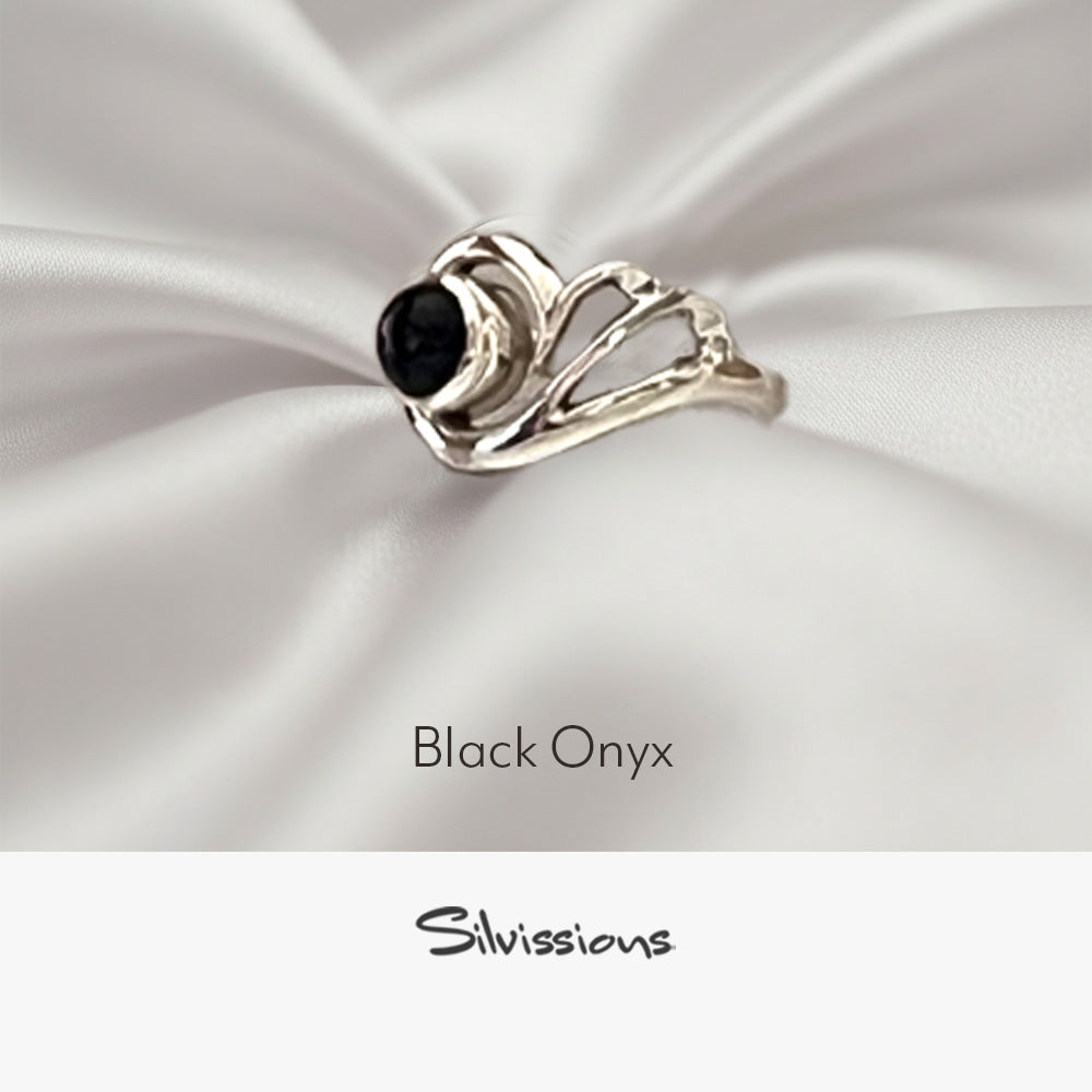 Silver ring with black onyx stone on a neutral background, featuring the brand 'Silvissions'.