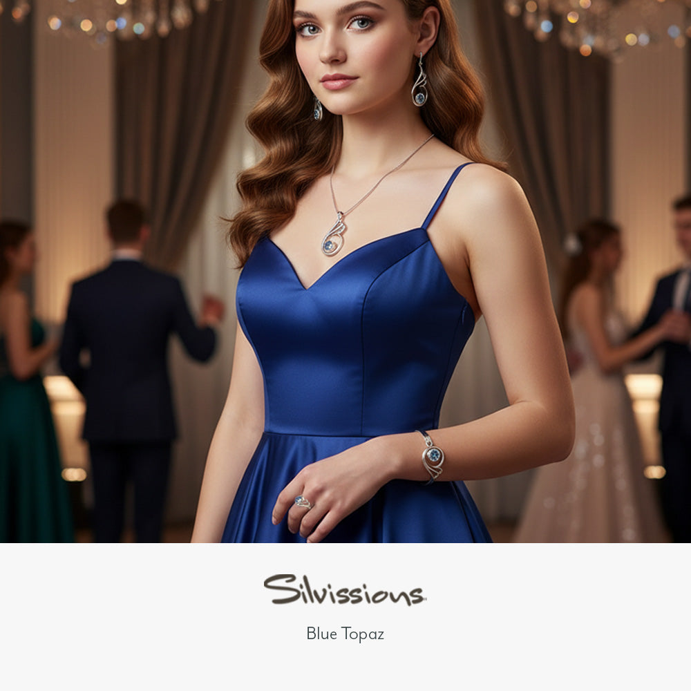 Woman in a blue dress with blue topaz gemstone jewelry at a formal event, featuring the brand 'Silvissions'.