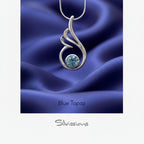 Silver pendant with blue gemstone on a white background, featuring the brand 'Silvissions'.