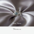 Silver ring with blue topaz gemstone on a neutral background, featuring the brand 'Silvissions'.