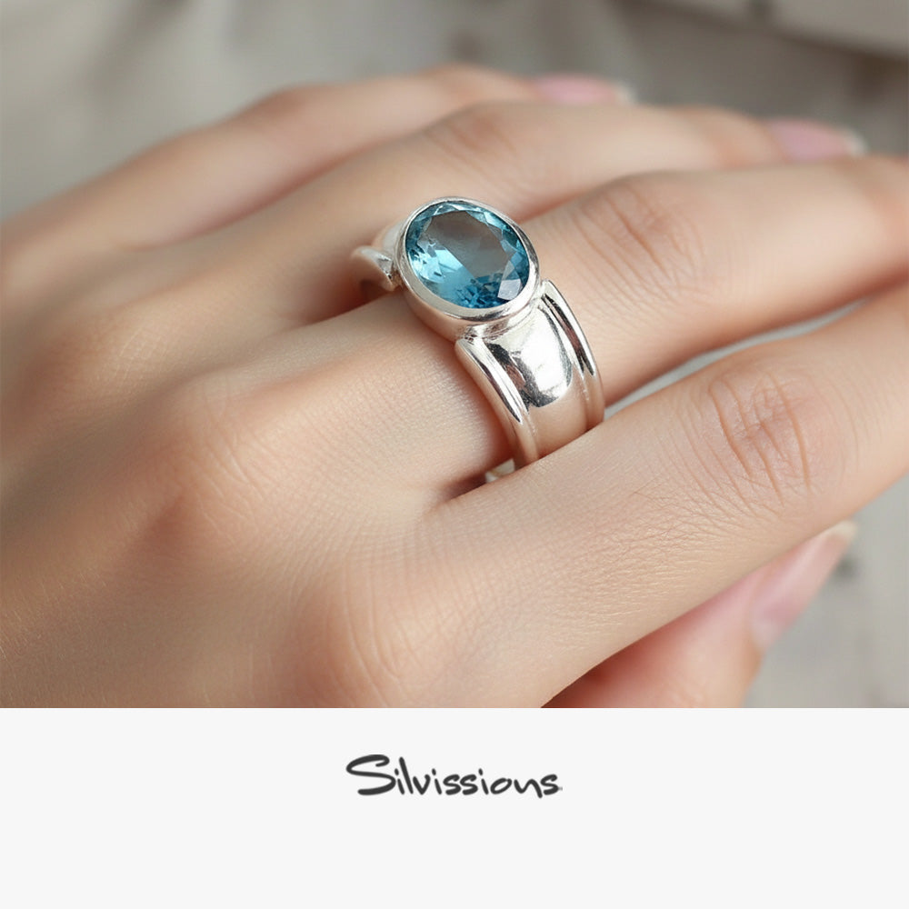 Silver ring with a blue gemstone on a hand, branded 'Silvissions'.