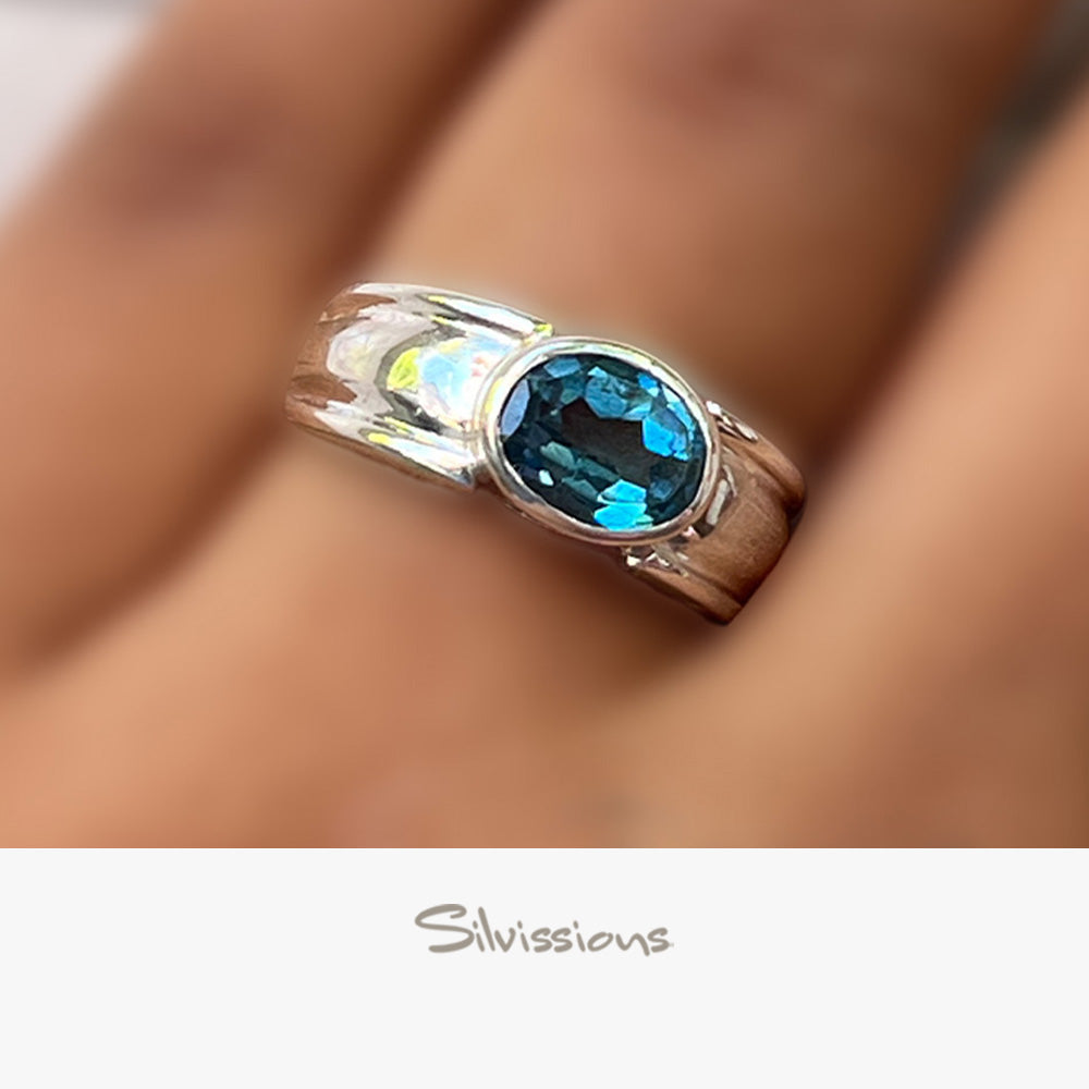 Ring with a blue gemstone on a blurred background, featuring the brand 'Silvissions'.