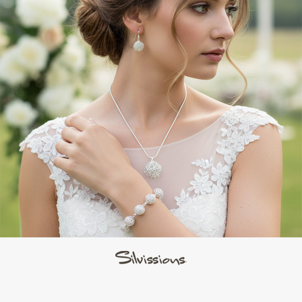 Woman wearing a necklace, earrings, and bracelet with a blurred floral background, featuring the brand 'Silvissions'.