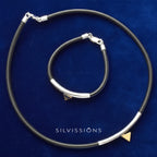 Black rubber choker with silver clasp on a blue background