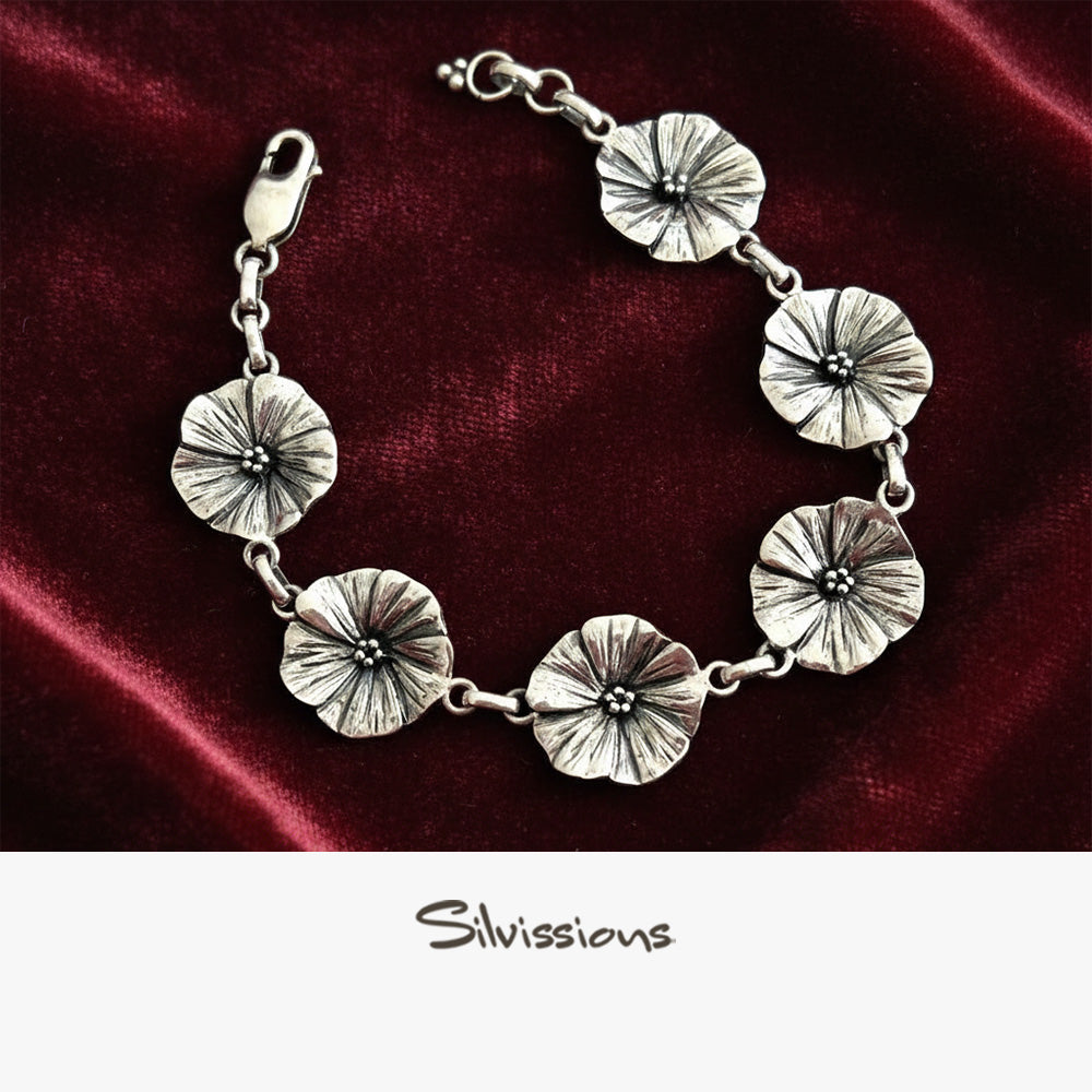 Silver floral bracelet on a red satin background with 'Silvissions' branding.
