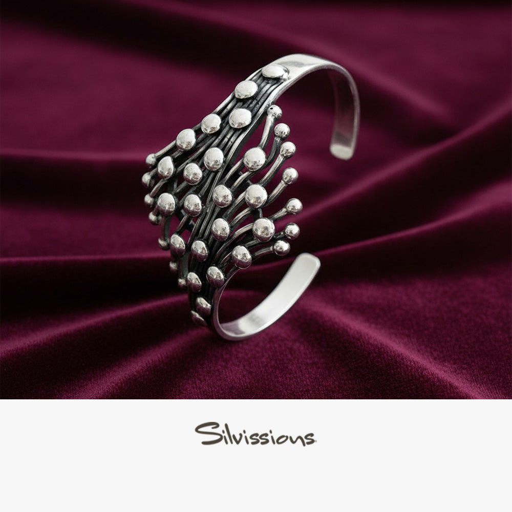 Silver bracelet on a burgundy fabric with 'Silvissions' branding.