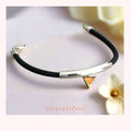 Black rubberr bracelet with silver and gold accents on a light background, featuring the brand 'Silvissions'.