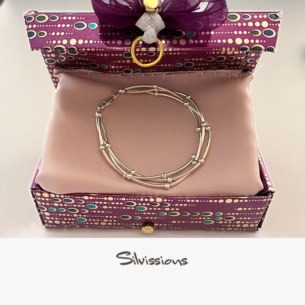 Silver bracelet in a purple wrapped handmade gist box with 'Silvissions' branding.