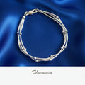 Silver bracelet on blue satin fabric with 'Silvissions' branding.