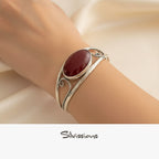 Silver bracelet with a red gemstone on a wrist, brand 'Silvissions' visible