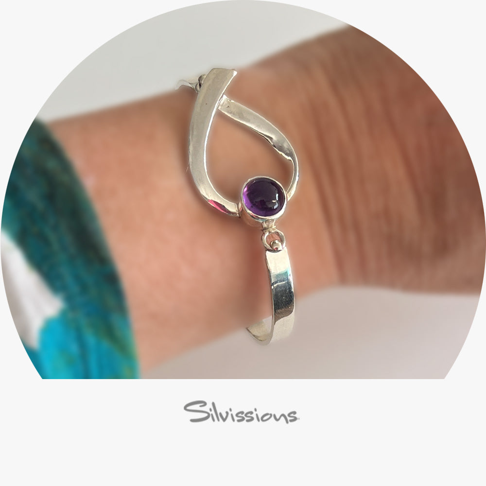 Silver bracelet with a purple gemstone on a wrist, brand 'Silvissions' visible