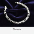 Silver bracelet on a dark purple fabric background with 'Silvissions' branding.
