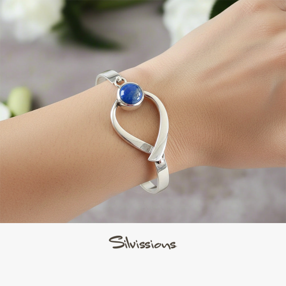 Silver bracelet with a blue gemstone on a wrist, brand 'Silvissions' visible