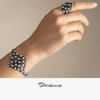 Hand wearing a silver bracelet and ring on a beige background with 'Silvissions' branding.