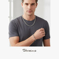 Man wearing a silver necklace and bracelet with a neutral background, featuring the brand 'Silvions'.