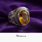 Silver ring with a citrine stone on purple fabric, featuring the brand 'Silvissions'.