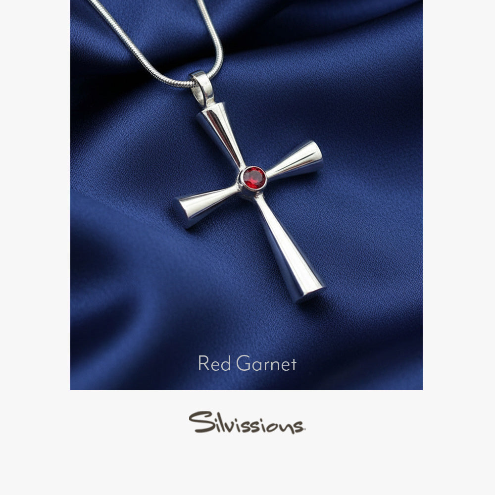 Silver cross pendant with red gemstone on blue fabric, branded 'Silvissions'.