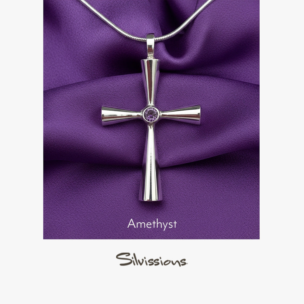 Silver cross pendant with amethyst stone on purple fabric, featuring the brand 'Silvissions'.