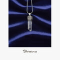 Crystal pendant necklace on a blue satin background with 'Silvissions' branding.