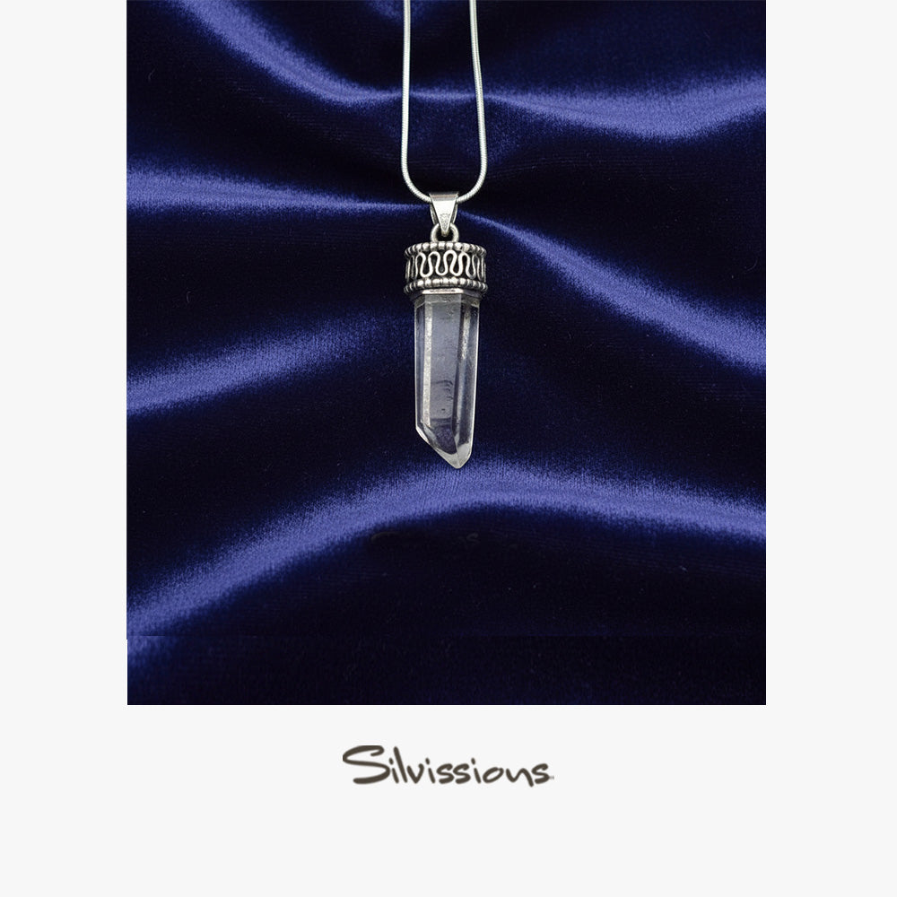 Crystal pendant necklace on a blue satin background with 'Silvissions' branding.