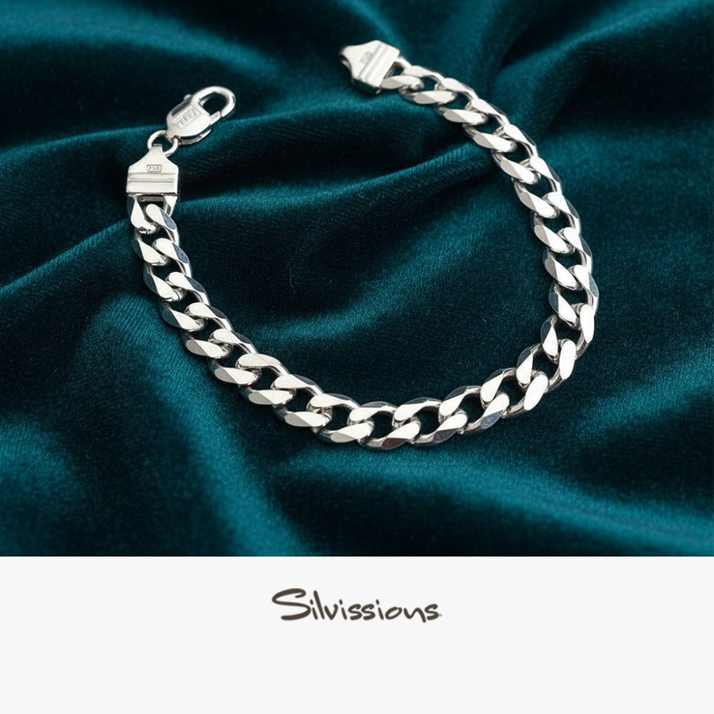 Silver cuban chain bracelet on teal fabric with 'Silvissions' branding.