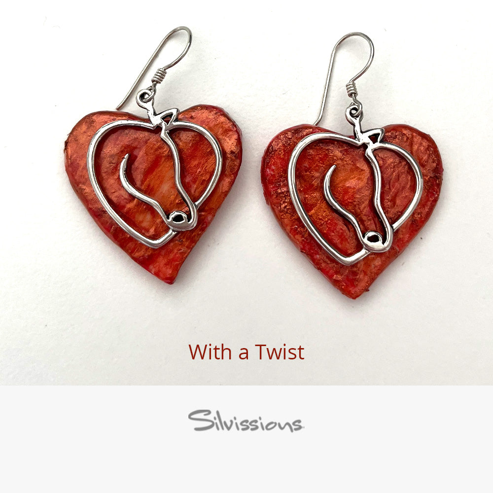 Heart-shaped earrings with silver horses on a beige background, branded 'Silvissions'.