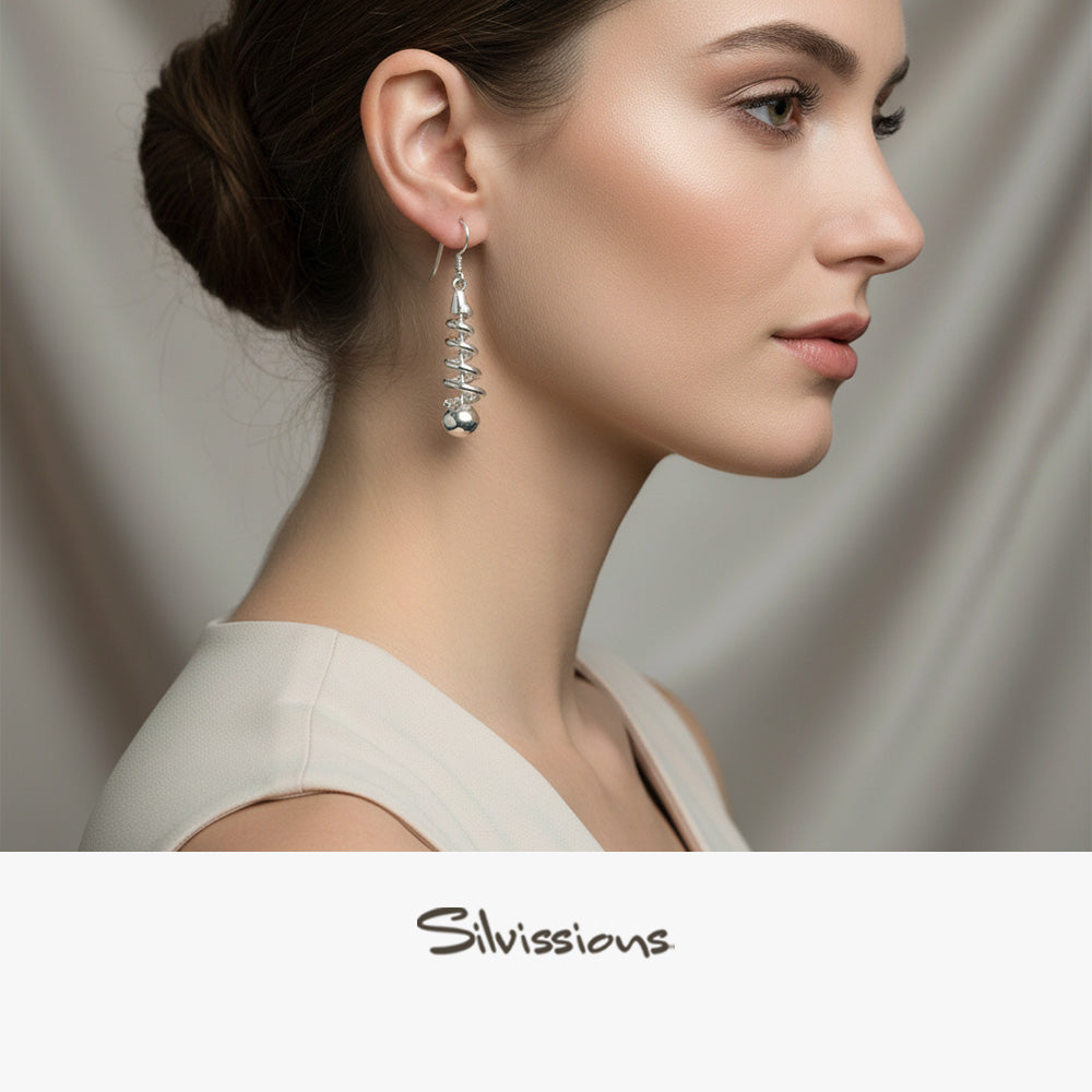 Woman wearing earrings with a neutral background, featuring the brand 'Silvissions'.