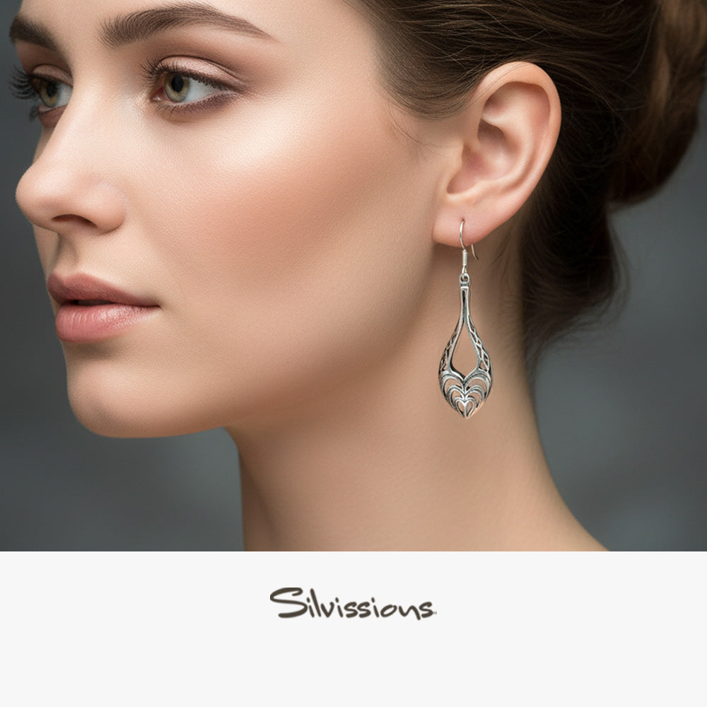 Close-up of a woman wearing a silver earring with 'Silvissions' branding.
