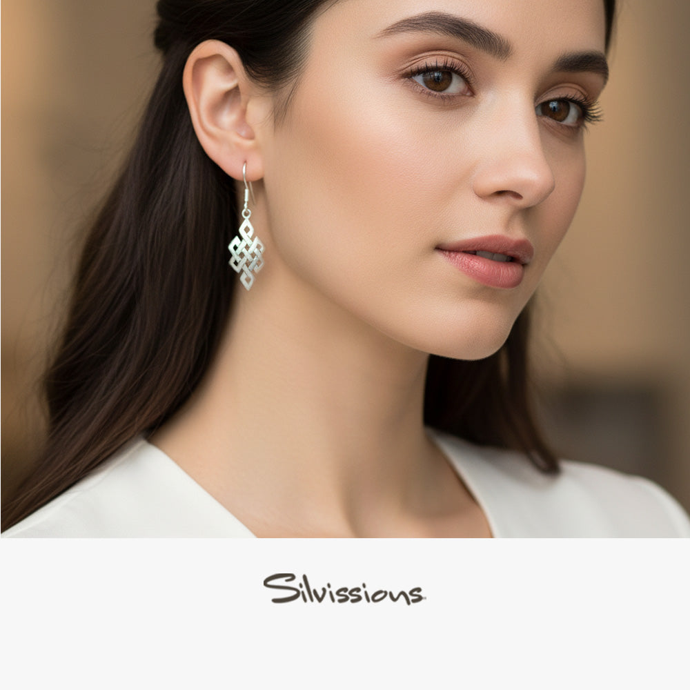Close-up of a woman wearing silver earrings with 'Silvissions' branding.