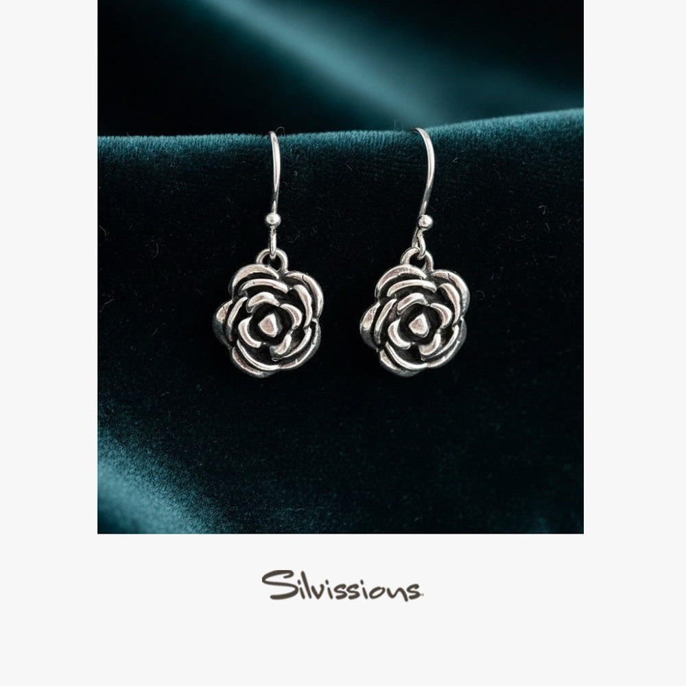 Silver rose-shaped earrings on a dark background with 'Silvissions' branding.