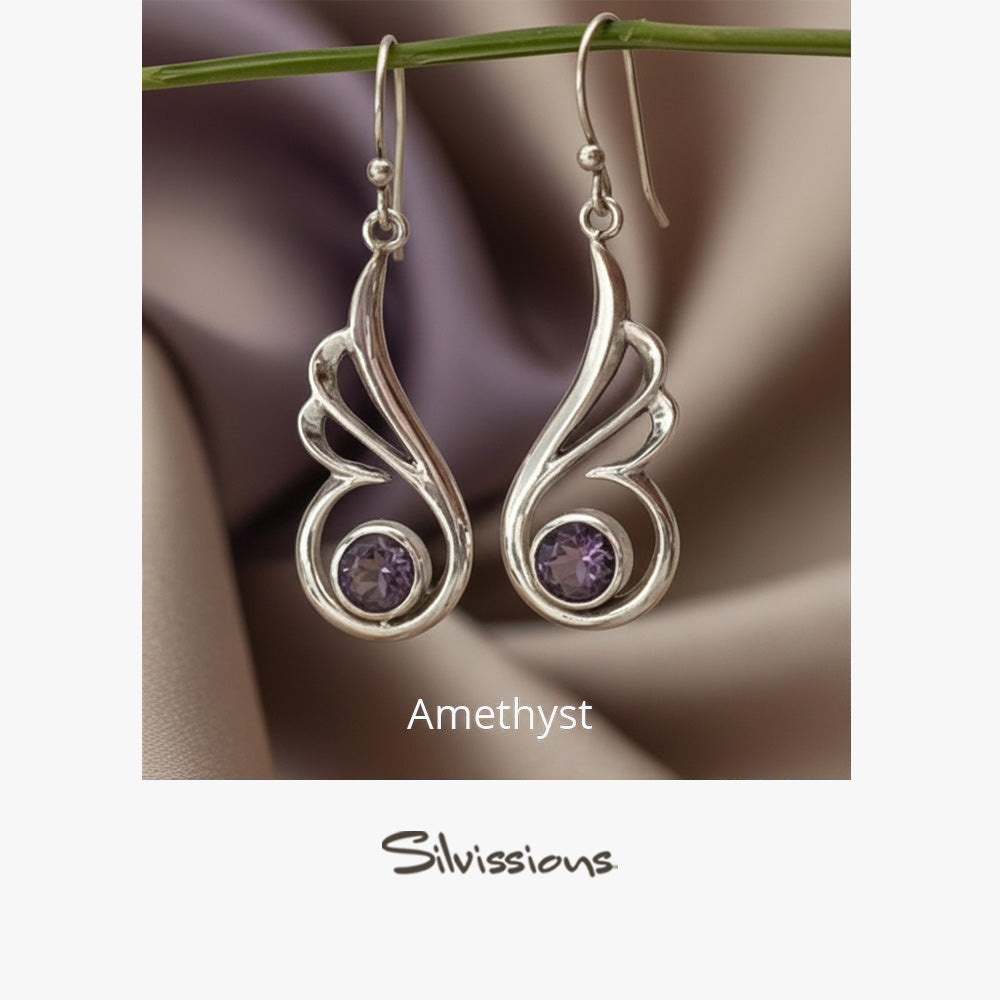 Silver earrings with purple gemstones on a fabric background