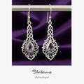 Silver earrings with purple gemstones on a purple background, branded 'Silviassions'.