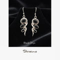 Black onyx earrings with silver designs on a black background, branded 'Silvissions'.