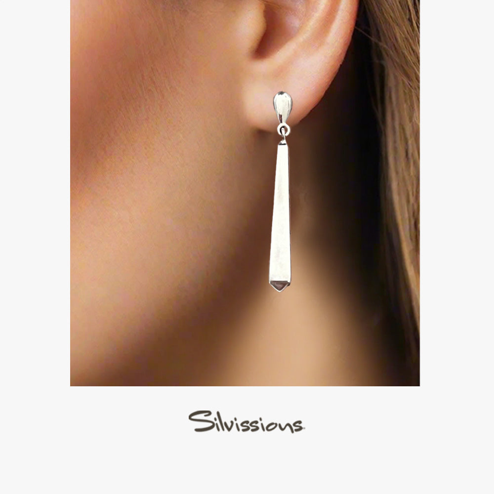 Silver earring worn on an ear with 'Silvassions' branding.