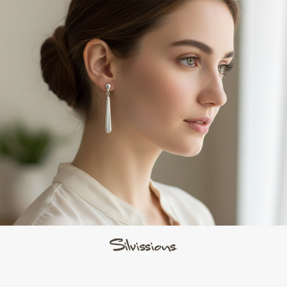 Woman wearing a silver earring with a blurred background and 'Silvissions' branding.