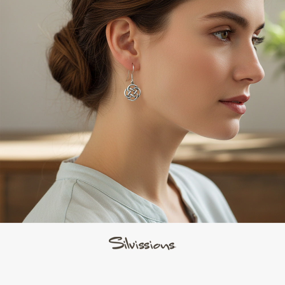 Woman wearing a silver earring with 'Silvissions' branding