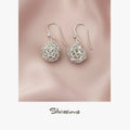 Silver wire ball earrings on a pink satin background with 'Silvissions' branding.