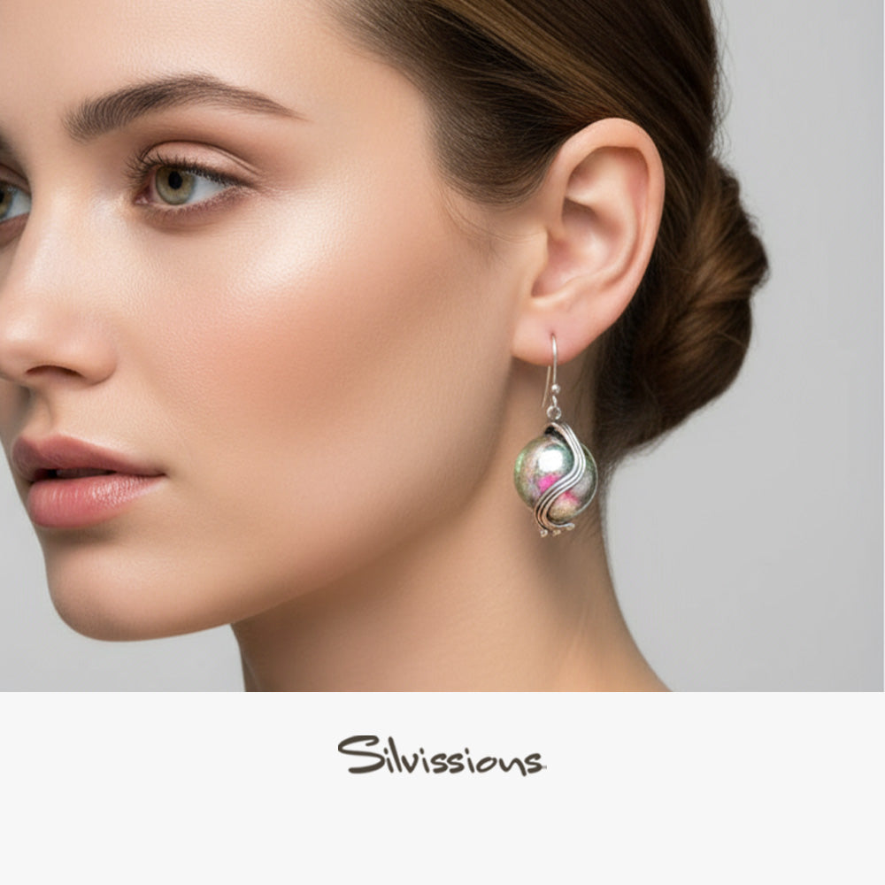 Close-up of a woman wearing a silver earring with 'Silvissions' branding.